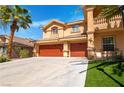 Beautifully landscaped two-story home with a three-car garage and well-maintained lawn at 10798 Tapestry Winds St, Las Vegas, NV 89141