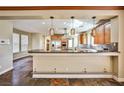 Open-concept kitchen featuring modern lighting fixtures, granite countertops, and stainless steel appliances at 1737 Cypress Manor Dr, Henderson, NV 89012