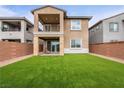 A backyard featuring a lush artificial lawn, a covered patio, and a balcony above at 175 Strada Fontana, Henderson, NV 89011