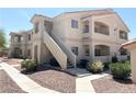 Well-maintained condo building with stucco siding and red tile roof, surrounded by desert landscaping and walking paths at 1881 W Alexander Rd # 2129, North Las Vegas, NV 89032