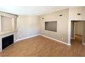 Cozy living room with hardwood floors, neutral paint, a fireplace, and an open doorway to another room at 1881 W Alexander Rd # 2129, North Las Vegas, NV 89032