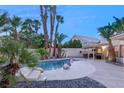 Backyard with a lagoon-style pool, mature palm trees, and an outdoor seating area at 1913 Madagascar Ln, Las Vegas, NV 89117