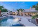 Beautiful pool with rock features, mature palm trees, and a covered outdoor seating area at 1913 Madagascar Ln, Las Vegas, NV 89117