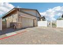 Spacious two-car garage with brick-paved driveway and gated access at 209 Bellini Peak Ave, Henderson, NV 89011