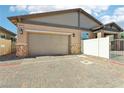 Attached two-car garage with brick-paved driveway and gated access at 209 Bellini Peak Ave, Henderson, NV 89011