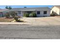 Modest single-story home featuring desert landscaping, a wide driveway, and window bars for added security at 255 Winona Dr, Henderson, NV 89015
