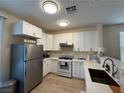 Updated kitchen featuring white cabinets, stainless steel appliances, and sleek countertops at 2633 Spider Cactus Ct, Las Vegas, NV 89106