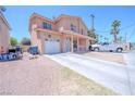 Two-story home with covered porch, white garage door, long driveway, and desert landscaping at 2906 Cedar Ave, Las Vegas, NV 89101