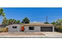 Charming single story home with desert landscaping and an orange front door at 3386 El Camino Real, Las Vegas, NV 89121