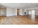 Spacious living room featuring wood floors, a stone fireplace, and sliding glass doors at 3386 El Camino Real, Las Vegas, NV 89121