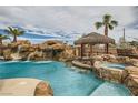 Resort-style pool featuring a rock waterfall, slide, and tiki hut with built-in bar at 3892 Pasilla Ave, Las Vegas, NV 89118
