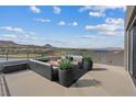 Outdoor patio area with comfortable seating, a fire pit, landscaping, and stunning lake and mountain views at 40 Heron Harbour Dr, Henderson, NV 89011