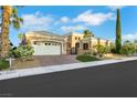 Beautiful home exterior with a paver driveway, lush landscaping, and a three-car garage at 4286 Pacifico Ln, Las Vegas, NV 89135