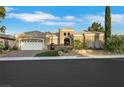 Charming single-story home with lush landscaping, decorative gate, and paved driveway under a bright blue sky at 4286 Pacifico Ln, Las Vegas, NV 89135