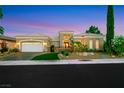 Attractive single-story home featuring well-manicured landscaping, decorative gate, and paved driveway at dusk at 4286 Pacifico Ln, Las Vegas, NV 89135