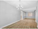 Well-lit dining room with wood-look tile flooring, modern lighting, and neutral paint colors for a serene atmosphere at 4562 Sparwood Dr, Las Vegas, NV 89147
