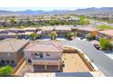 Expansive backyard of a single Gathering home with desert landscaping, a covered patio and mountain views at 512 Los Dolces St, Las Vegas, NV 89138