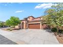 Inviting home featuring a well-maintained front yard, desert landscaping and a spacious three-car garage at 512 Los Dolces St, Las Vegas, NV 89138