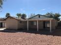 Back exterior view of house with covered patio and xeriscaping at 6196 W University Ave, Las Vegas, NV 89103