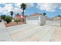 Wide shot of a home's exterior with a long driveway, two car garage, and low maintenance desert landscaping at 628 Bay Bridge Dr, North Las Vegas, NV 89032