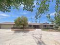 Single-story home with large driveway, desert landscaping, and mature trees offering ample shade at 6315 Eldora Ave, Las Vegas, NV 89146