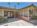 Welcoming covered front porch with decorative brickwork and ornate metal security doors at 6315 Eldora Ave, Las Vegas, NV 89146