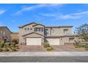 Charming stucco two-story home with a brick driveway and well-maintained landscaping at 7051 Denio Island St, North Las Vegas, NV 89084