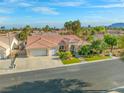 Wide aerial shot of the house with desert landscaping, a three car garage and well maintained exterior at 7411 Brittlethorne Ave, Las Vegas, NV 89131