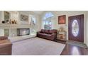 Comfortable living room with fireplace, hardwood floors, and a large window at 8224 Fawn Meadow Ave, Las Vegas, NV 89149