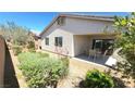A cozy outdoor patio with a table and chairs, surrounded by a well-kept garden and privacy fence at 8305 Minots Ledge Ave, Las Vegas, NV 89147