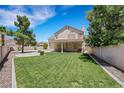 A well-maintained backyard with lush green lawn and a covered patio area at 8481 Lambert Dr, Las Vegas, NV 89147