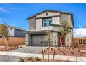 Charming two-story home featuring a brick driveway, gray stucco, stone accents, and a red front door at 1007 Gentle Swan St # Lot 699, Henderson, NV 89011