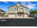 Three-car garage townhome with a stylish exterior, neutral color palette, and well-manicured surroundings at 1101 Elation Ln # 2, Henderson, NV 89002