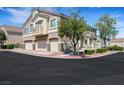 Multi-story townhome featuring a three-car garage, balcony, and nicely landscaped surroundings at 1101 Elation Ln # 2, Henderson, NV 89002