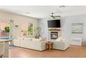 Bright living room with a fireplace, large TV, comfortable seating, and views of the backyard pool at 11226 Kenyan Sunshine Ct, Las Vegas, NV 89138