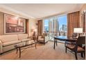 Comfortable living room features a plush sofa, sitting chair, and a beautiful city view at 145 E Harmon Ave # 919, Las Vegas, NV 89109