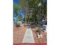 Scenic view of community walking path with trees and well-maintained landscaping alongside residences at 2116 Bavington Dr # C, Las Vegas, NV 89108