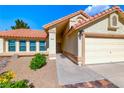 Close-up exterior of home featuring a two-car garage, desert landscaping and tile roof at 234 Geronimo Ct, Henderson, NV 89074