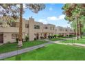Well-maintained townhouses featuring sidewalks, manicured lawns, mature trees and desert landscaping at 2661 Ruthe Duarte Ave, Las Vegas, NV 89121