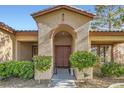 Charming front entrance features an arched entryway and manicured landscaping at 313 Glenridding St, Las Vegas, NV 89183