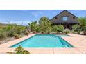 Backyard pool with mature landscaping around a house with a blue sky at 3330 Wedo Way, North Las Vegas, NV 89031