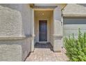 Covered entryway featuring stone columns and a dark front door with a brick paver walkway at 3716 W Colton Ave, North Las Vegas, NV 89032
