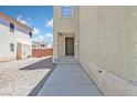 Inviting front entrance with neutral stucco exterior and low maintenance gravel landscaping at 4132 Joyous St, North Las Vegas, NV 89032
