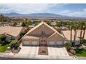 Expansive three-car garage home with desert landscaping offers curb appeal and ample parking against mountain views at 414 Crystal Canyon Dr, Mesquite, NV 89027