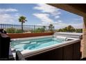 Relaxing hot tub on a patio with a view of lush landscaping and beautiful palms, perfect for outdoor enjoyment at 414 Crystal Canyon Dr, Mesquite, NV 89027