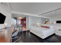 Contemporary bedroom with dark floors, white walls, a modern bed, and a kitchen area at 4381 W Flamingo Rd # 1206, Las Vegas, NV 89103