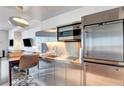 A modern stainless steel kitchenette featuring a sink, microwave, and mini refrigerator at 4381 W Flamingo Rd # 1206, Las Vegas, NV 89103
