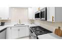 Modern kitchen with white cabinets, quartz countertops, stainless steel appliances and gas range at 5191 Caliente St # 84, Las Vegas, NV 89119