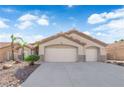 Inviting single-story home with a dual-car garage, desert landscaping, and warm neutral tones at 5437 Escallonia St, Las Vegas, NV 89149