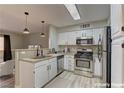 Efficient kitchen with stainless steel appliances, white cabinets, and modern lighting fixtures with convenient breakfast bar at 5710 E Tropicana Ave # 1216, Las Vegas, NV 89122
